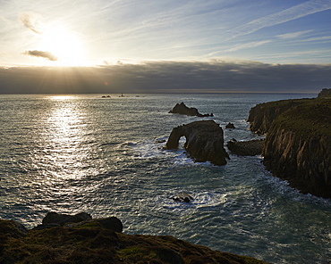 Sunset at Land's End over Enys Dodman rock arch, Longships Lighthouse, Cornwall, England, United Kingdom, Europe