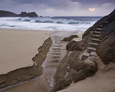 Stormy conditions on the beach looking out towards Logan Rock at Porthcurno, Cornwall, England, United Kingdom, Europe