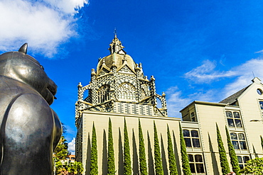 A view of the Rafael Uribe Uribe Palace of Culture with the Fernando Botero statue Gato (Cat) in the foreground, Medellin, Colombia, South America