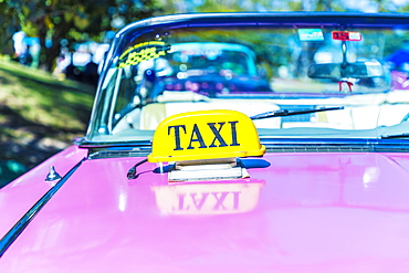 A taxi sign on a classic American car used as a taxi in Varadero, Cuba, West Indies, Caribbean, Central America