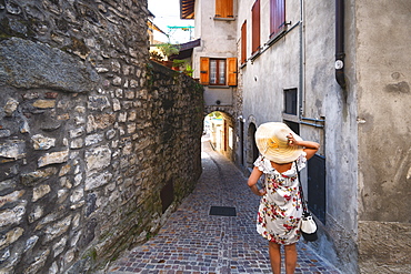 Woman lost in the alleysof Monte Isola on the Iseo Lake, the largest lake island in Europe, Province of Brescia, Lombardy, Italy, Europe