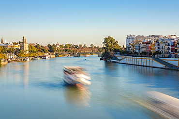 Long exposure of Betis Street in Triana and Guadalquivir River and the Torre del Oro on the left bank in late afternoon, Seville, Andalucia, Spain, Europe