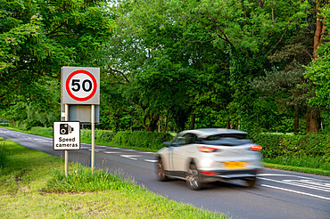 Vehicle travelling towards 50mph and speed camera signs on a Cheshire road, Cheshire, England, United Kingdom, Europe