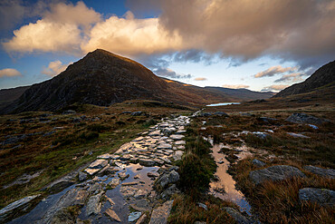 Stone footpath leading towards Llyn Ogwen with view of Tryfan in Snowdonia National Park. Ogwen, Conwy, Wales