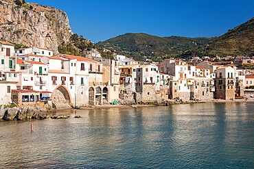 View across harbour to the Old Town, houses clustered together along waterfront, Cefalu, Palermo, Sicily, Italy, Mediterranean, Europe