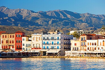 View across the Venetian Harbour to colourful waterfront buildings beneath the Lefka Ori, Hania (Chania), Crete, Greek Islands, Greece, Europe