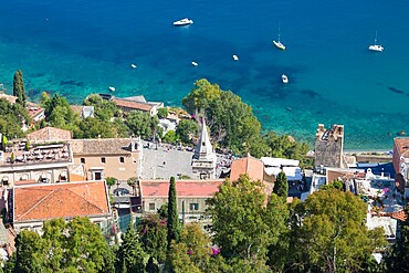 View down steep hillside over rooftops to Piazza IX Aprile and the Ionian Sea below, Taormina, Messina, Sicily, Italy, Mediterranean, Europe