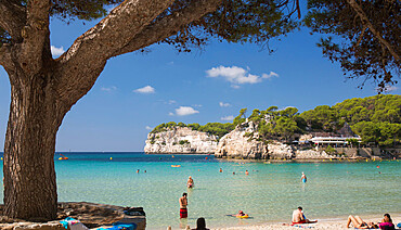 View from sandy beach across the clear turquoise waters of the Mediterranean Sea, Cala Galdana, Menorca, Balearic Islands, Spain, Mediterranean, Europe