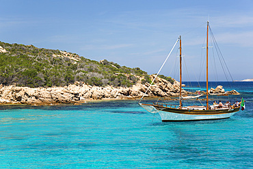 Wooden sailing boat anchored in clear turquoise water off Cala Granara, Spargi Island, La Maddalena Archipelago National Park, Sassari, Sardinia, Italy, Mediterranean, Europe