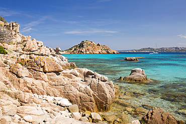 View from rocks across the clear turquoise waters of Cala Corsara to the pink granite headland of Punta Rossa Corsara, Spargi Island, La Maddalena Archipelago National Park, Sassari, Sardinia, Italy, Mediterranean, Europe