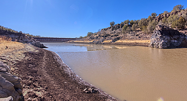 Shoreline view of the historic Bainbridge Steel Dam near Ash Fork Arizona in the Kaibab National Forest. It was originally constructed in the late 1800s and is now a historic landmark that is open to the public.