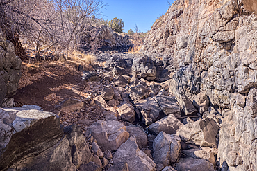 Basalt boulders and cliffs in a section of Johnson Canyon halfway between the Bainbridge Steel Dam and Stone Dam near Ash Fork Arizona in the Kaibab National Forest.