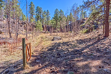 An old gate to the sinkhole called the Keyhole Sink in Williams Arizona within the Kaibab National Forest.