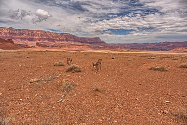 An abandoned lawn chair in view of Vermilion Cliffs near Marble Canyon Arizona from US89A on a mostly cloudy day. Located between the little town of Bitter Springs on the Navajo Reservation and the Vermilion Cliffs National Monument.