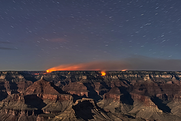 Dragon Bravo Wildfire on Grand Canyon North Rim viewed from Yavapai Point on South Rim Arizona at night under moonlight.