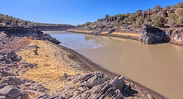 Shoreline view of the historic Bainbridge Steel Dam near Ash Fork Arizona in the Kaibab National Forest. It was originally constructed in the late 1800s and is now a historic landmark that is open to the public.