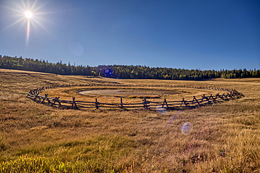 Deer Lake Sinkhole on the Kaibab Plateau in northern Arizona near sunset. The wood fence is to keep cattle from getting stuck in the hole.