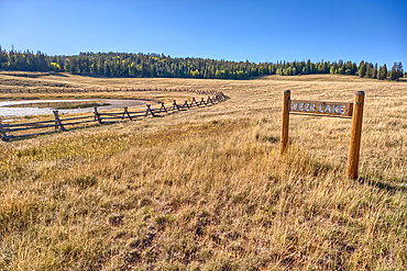 Deer Lake Sinkhole on the Kaibab Plateau in northern Arizona near sunset. The wood fence is to keep cattle from getting stuck in the hole.