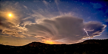 An isolated storm cell near Chino Valley being lit by the Moonlight during the summer monsoon season, Arizona, United States of America, North America