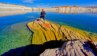 A hiker standing on a rock peninsula at Lake Powell, Arizona, United States of America, North America