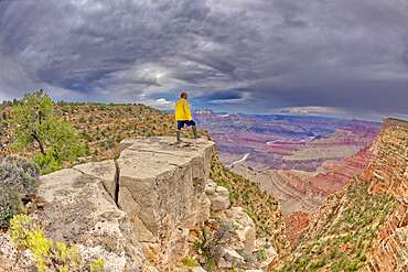 A hiker standing on a cliff between Zuni and Papago Points at Grand Canyon on a stormy day, Grand Canyon National Park, UNESCO World Heritage Site, Arizona, United States of America, North America