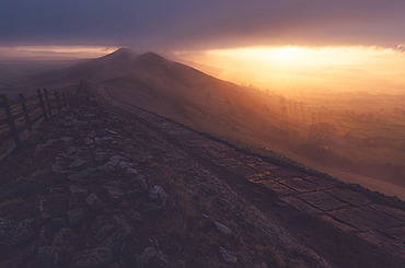 The path on Mam Tor runs off and out of view into a foggy sunrise, Peak District, Derbyshire, England, United Kingdom, Europe