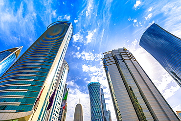 Low angle view of Al Fardan Towers complex and Doha Tower, iconic glassed high rises in West Bay, Doha, Qatar, Middle East