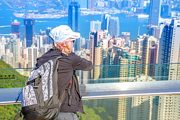 Tourist looking at the view of Victoria Harbour from Peak Tower, Hong Kong, China, Asia