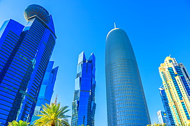 Low angle view of Woqod Tower and Alfardan Towers in West Bay area, modern glassed skyscrapers in Downtown Doha, Qatar, Middle East