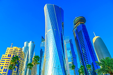 Low angle view of Al Fardan Towers complex and Doha Tower, iconic glassed high rises in West Bay, skyscrapers of Financial District in sunset light in 2019, Doha, Qatar, Middle East