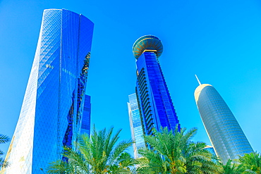 Low angle view of Al Fardan Towers complex and Doha Tower, iconic glassed high rises in West Bay, skyscrapers of Financial District in sunset light in 2019, Doha, Qatar, Middle East