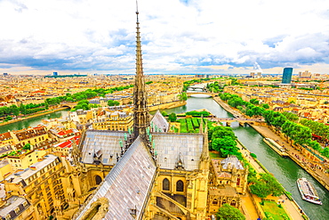 Detail of the spire of Notre Dame Cathedral (Our Lady of Paris) with statues, and city skyline, Paris, France, Europe