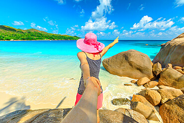 Blonde woman holding hand of her friend at Anse Lazio, Praslin Island, Seychelles, Indian Ocean, Africa