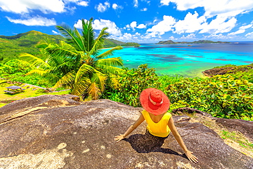 Panorama with woman looking to Cote d'Or Bay, with Curieuse, St. Pierre and Chauvre Souris Island, Anse Gouvernement, Praslin, Seychelles, Indian Ocean, Africa