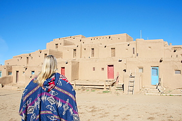 Woman standing in front of Taos Pueblo, UNESCO World Heritage Site, Taos, New Mexico, United States of America, North America