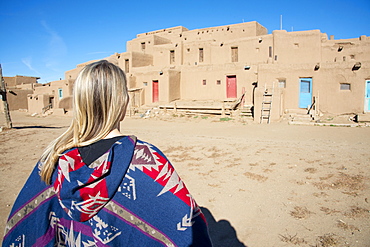 Woman standing in front of Taos Pueblo, UNESCO World Heritage Site, Taos, New Mexico, United States of America, North America