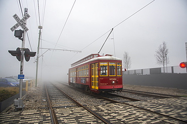 Street car emerging from dense morning fog in the French Quarter of New Orleans, Louisiana, United States of America, North America