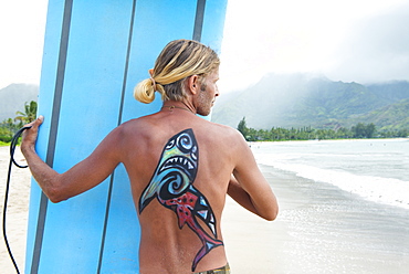 Surfer in Hanalei Bay, with a shark painted on his back, Kauai, Hawaii, United States of America, North America