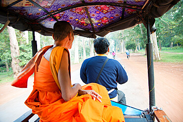 Buddhist monk riding in a tuktuk at the Angkor archaeological park in Siem Reap, Cambodia, Indochina, Southeast Asia, Asia