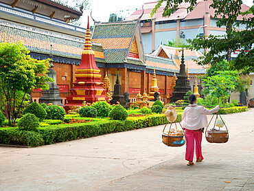 Woman carrying baskets over her shoulders outside a temple in Siem Reap, Cambodia, Indochina, Southeast Asia, Asia