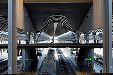 A passenger crosses a walkway at Seville's main train station, Seville Santa Justa, Seville, Andalucia, Spain, Europe