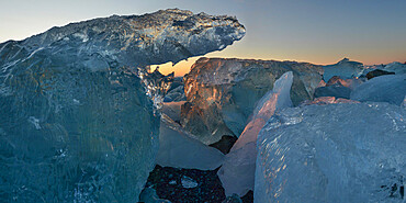 Pieces of glacial ice over black sand being washed by waves, Iceland, Polar Regions