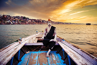 Indian Hindu Sadhu (saint) in boat on River Ganges in Varanasi, Uttar Pradesh, India, Asia