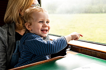 Two year old boy and Mother in old steam train carriage pointing out of window, Bluebell Railway, Sussex, England, United Kingdom, Europe