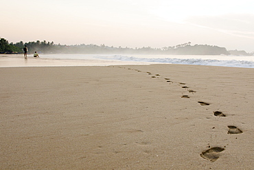 Two men watching the sunrise on Talalla beach, Sri Lanka, Asia