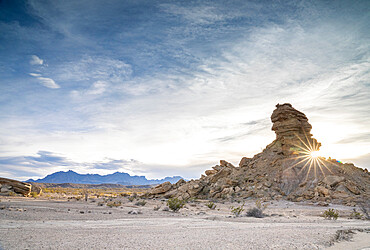 Sunburst through the desert rocks with Chisos Mountains in the background, Big Bend National Park, Texas, United States of America, North America