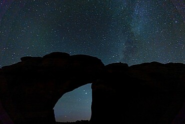 Starry sky viewed through Broken Arch, Arches National Park, Utah, United States of America, North America