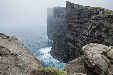 A misty day in the Faroe Islands reveals the towering cliffs at Traelanipa, Faroe Islands, Denmark, Atlantic, Europe