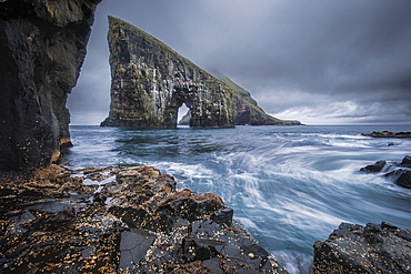 Dramatic Sea Arch of Drangarnir and waves crashing on the Faroe Islands coast, Faroe Islands, Denmark, Atlantic, Europe