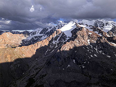 Snow-capped peaks and lush valleys at sunset showcased in a stunning landscape, Kyrgyzstan, Central Asia, Asia